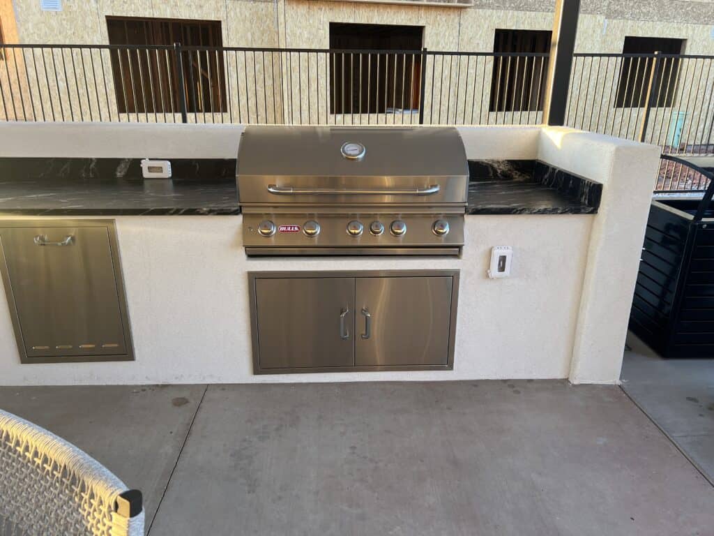 Outdoor stainless steel grill on patio.