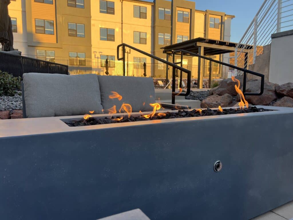 Outdoor patio with modern fire pit and seating.