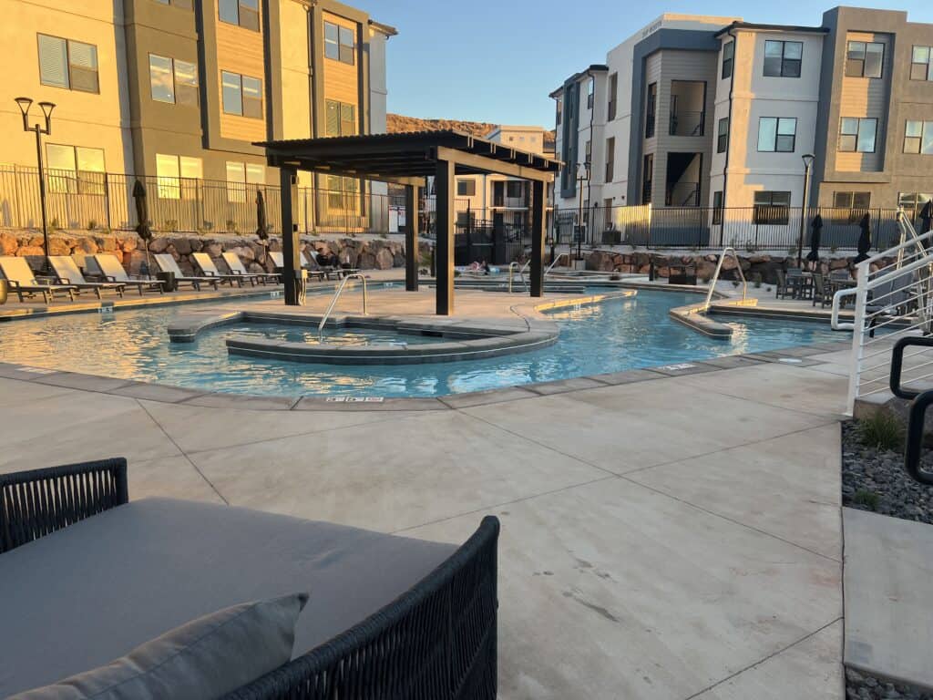 Outdoor apartment pool with surrounding lounge chairs