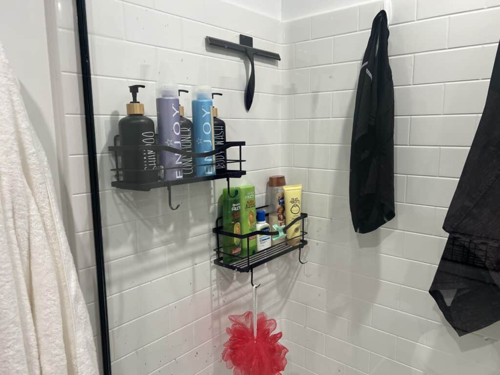 Shower with toiletries and hanging towel.