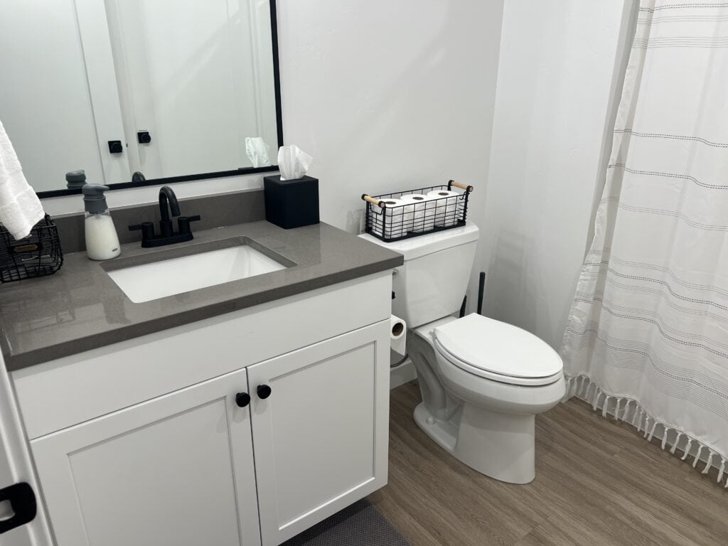 Modern bathroom with sink, toilet, and shower curtain.