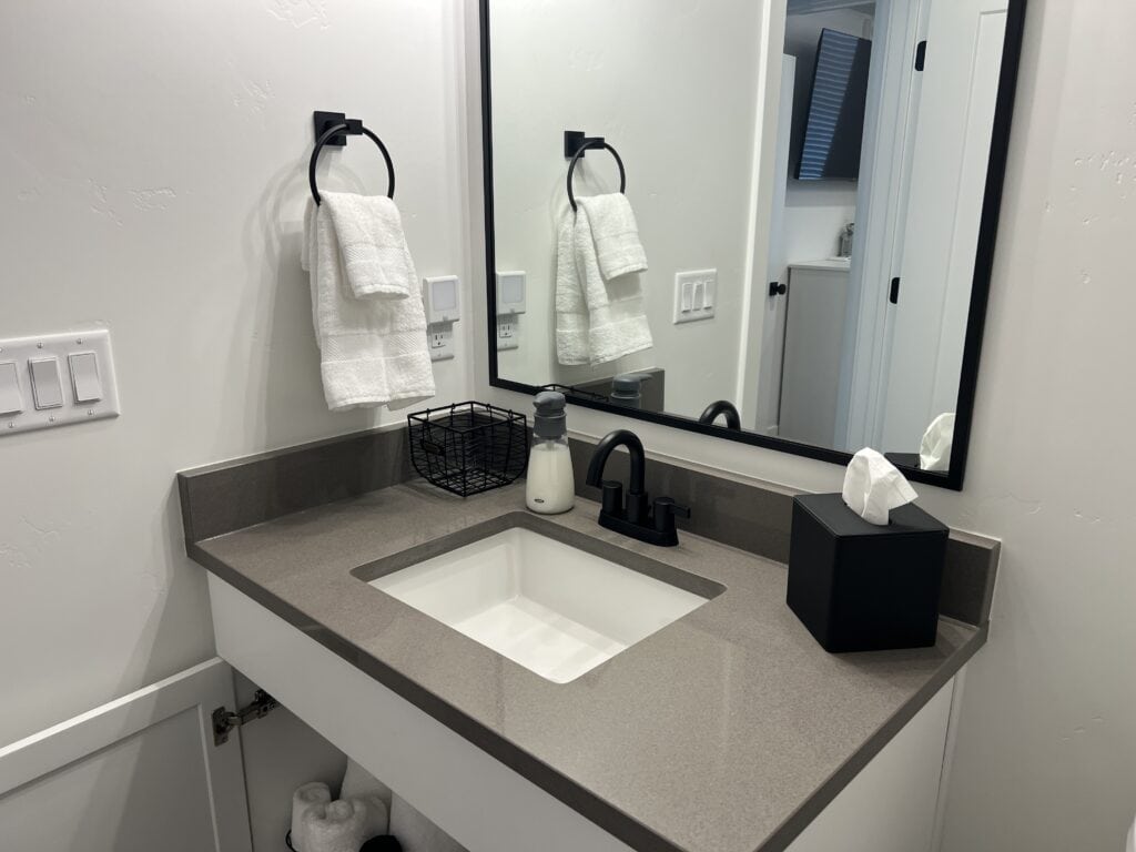 Modern bathroom vanity with towels and accessories.