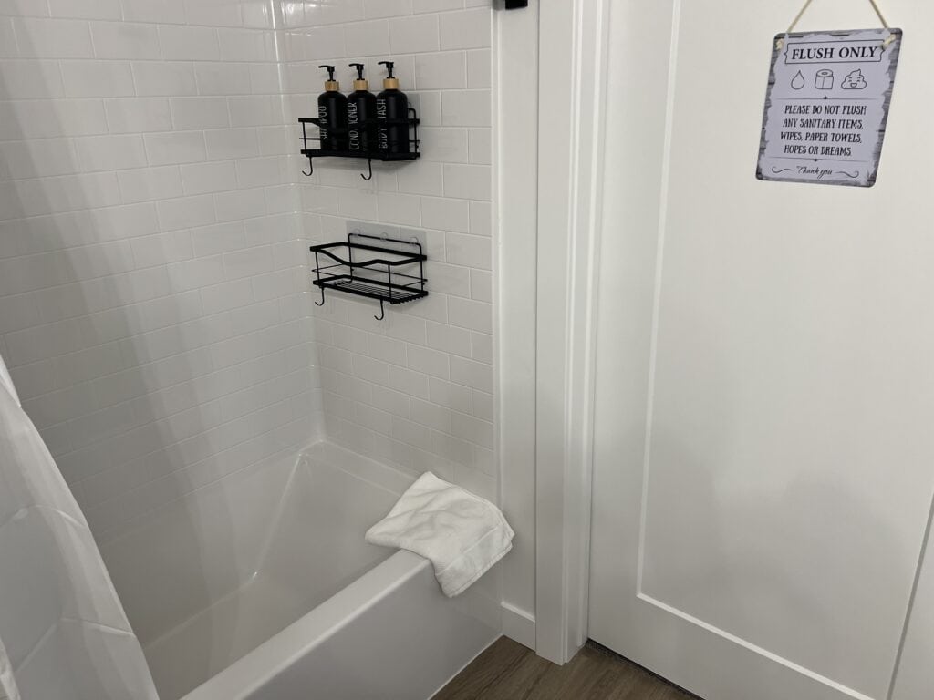 Bathroom with shower and shelf for toiletries.