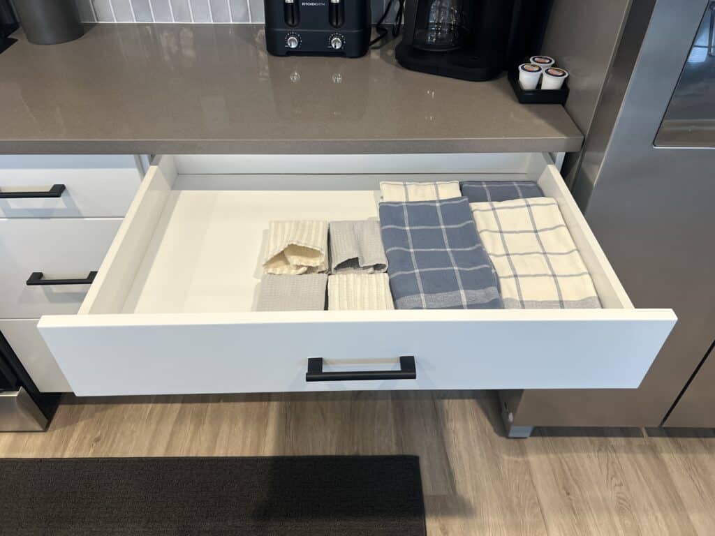 Organized kitchen drawer with folded dish towels.