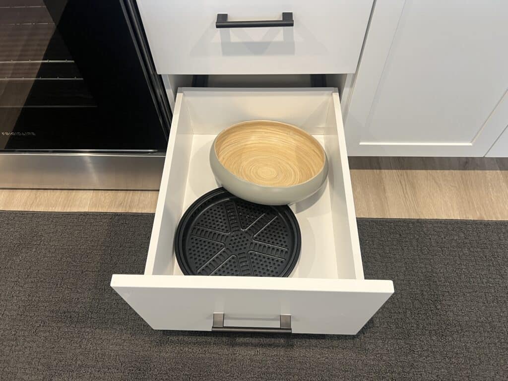 Open kitchen drawer with bowls inside.