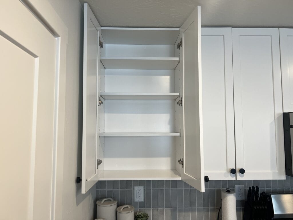 Open kitchen cabinet with empty shelves.